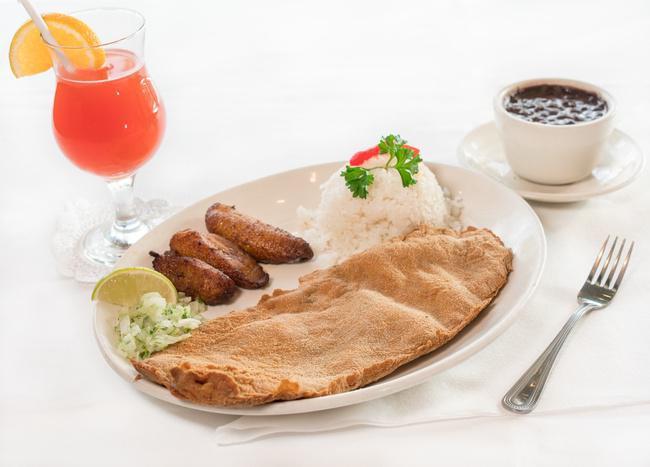 Breaded Steak · A breaded palomilla steak fried and topped with chopped onions. Served with white rice, black beans and sweet plantains.