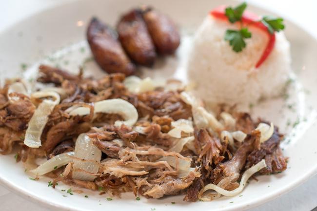 Roast Pork · Traditionally our national dish marinated in tasty tropical spices and mojo juice. Oven roasted then grilled with sauteed onions. Served with white rice, black beans and sweet plantains