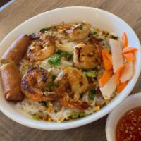 Bun Tom Nuong Cha Gio · Grilled shrimp and egg roll over vermicelli and vegetables.