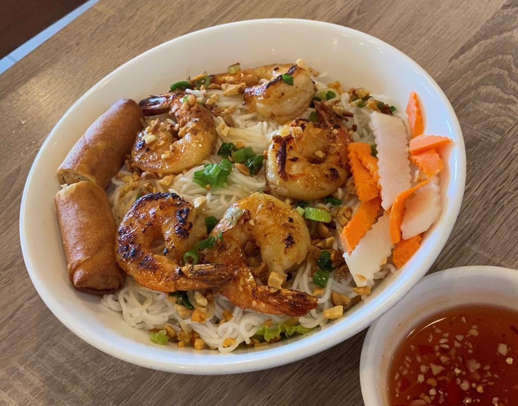 Bun Tom Nuong Cha Gio · Grilled shrimp and egg roll over vermicelli and vegetables.