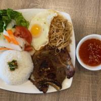 Com Bi Suon Trung Op La · Grilled pork chop, shredded pork and fried egg with steamed rice and vegetables.