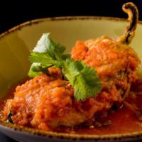 Chile Relleno con Queso · Roasted poblano pepper stuffed with queso fresco, served in a light tomato sauce with rice a...