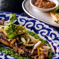 Bistec Tampiquena · 12oz Sirloin steak with roasted poblanos, onions,guacamole, queso quesadilla, refried beans ...