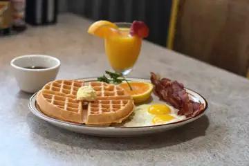 Waffle Combo · Crispy Belgian waffle topped with 2 eggs and your choice of two sausage links or 2 bacon strips.