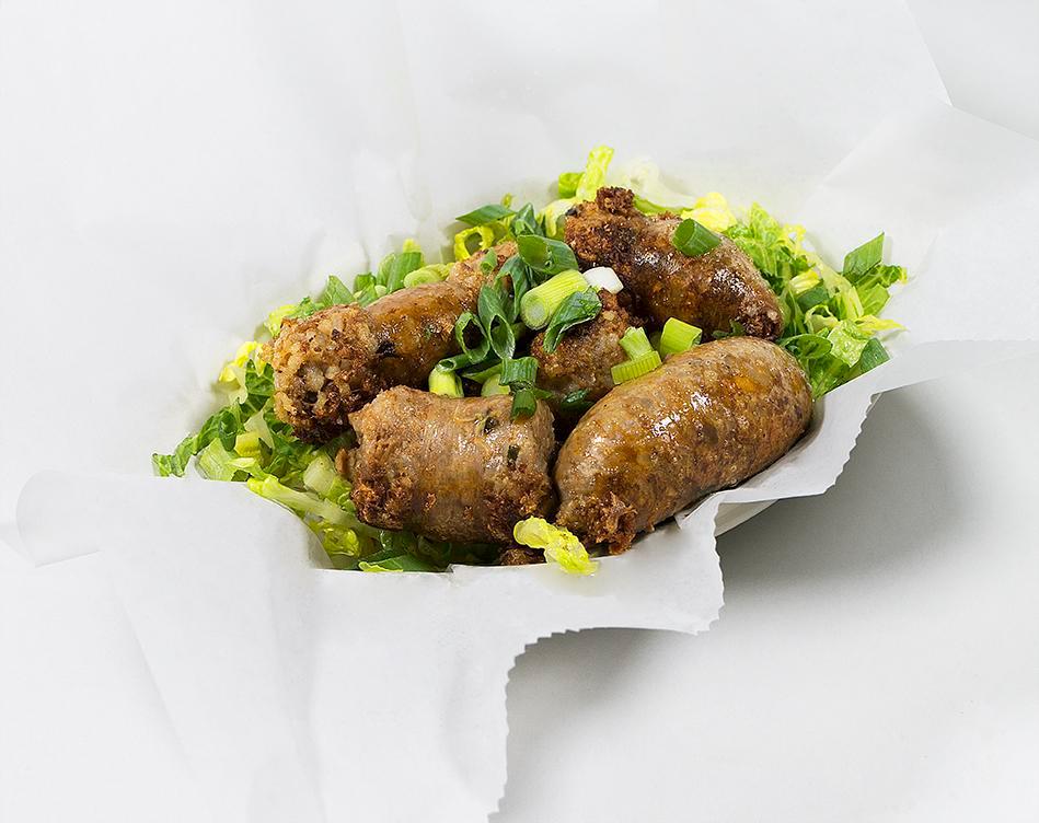 Cajun Boudin Sausage · Savory Cajun Seasoned Sausage Links made with Chicken and Pork, served over a bed of fresh Romaine Lettuce