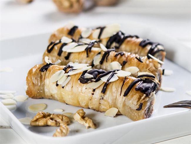 Chocolate Baklava · A savory dessert, which features flaky phyllo dough wrapped around a blend of chopped walnuts and almonds in a sweet syrup mixture topped with ribbons of chocolate. Allergen: Wheat, Milk, and Tree Nuts.