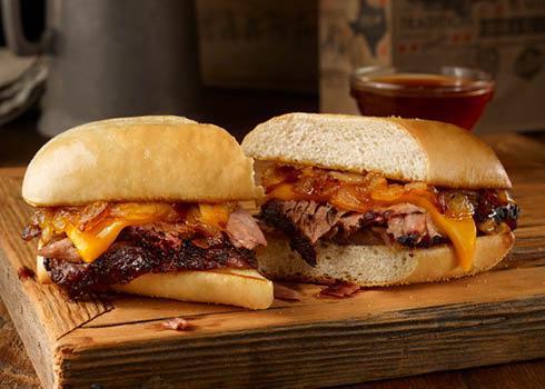 Pit Dip Sandwich · Sliced brisket, pit-smoked caramelized onions, & cheddar cheese on a toasted hoagie bun. Served with smoky beef dipping sauce