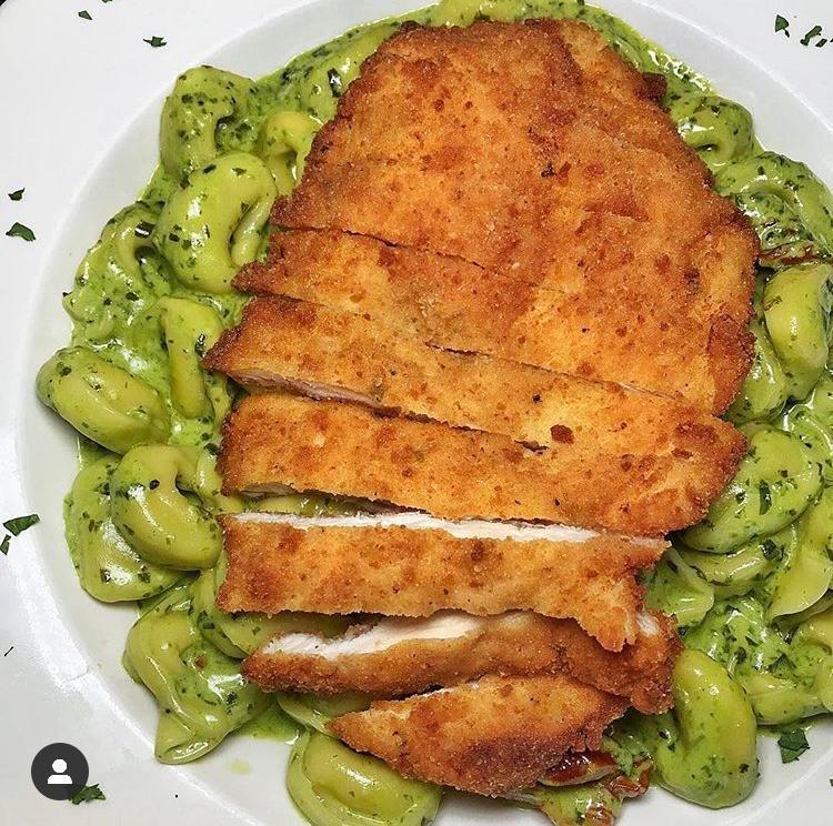 Tortellini Cotto · Creamy basil pesto sauce, sun-dried tomatoes and cheese tortellini finished with a sliced breaded chicken cutlet.
