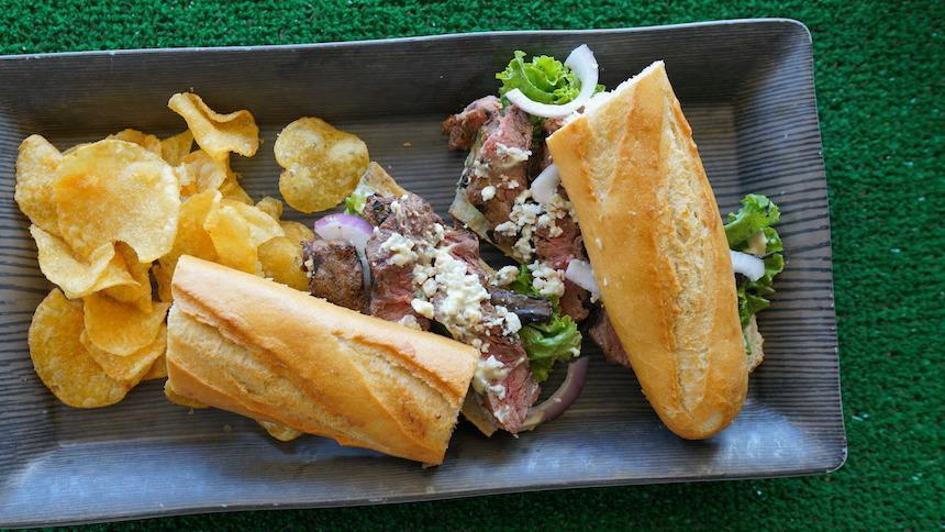 Chipotle Steak Sandwich · grilled USDA choice flat iron steak, romaine, bleu cheese, portabella mushrooms, red onion and chipotle fennel sauce on a French baguette served with Cape Cod chips