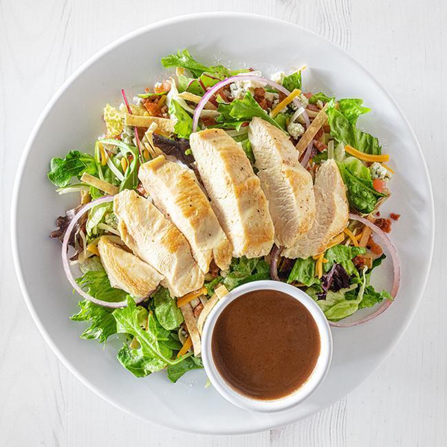 Hurricane Chicken Salad · Our signature salad features your choice of grilled or crispy chicken on a bed of mixed greens, topped with crumbly bleu cheese, bacon, cheddar jack cheese, red onions, diced tomatoes and crispy tortilla strips. Served with your choice of dressing. (850-1390 cal.)