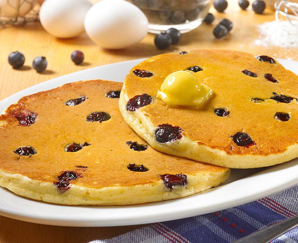 Wild Blueberry Sweet Cakes · Pancakes Perfected: Two platter-sized, thick and fluffy pancakes, topped with sweetness and bursting with plump blueberries (Cal 650)