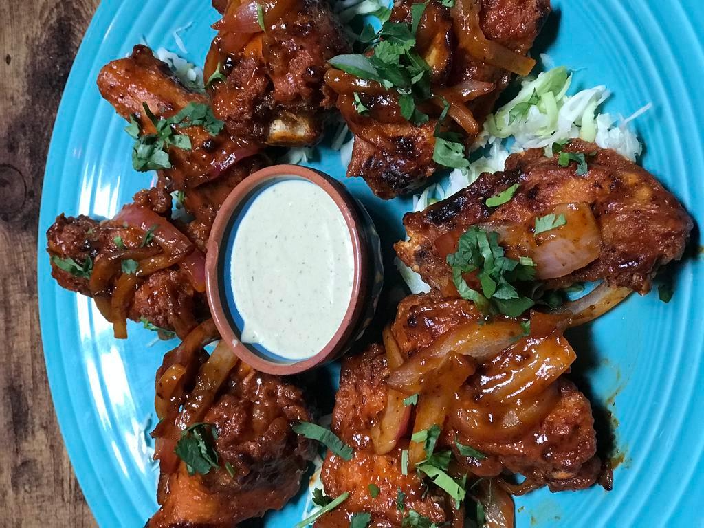 Alitas de Pollo · 8 pieces chicken wings, flash-fried and tossed in a tangy cayenne pepper reduction. Served with creamy poblano dipping sauce. Gluten free.