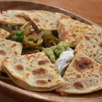 The Quesadilla · Served with pico de gallo, fresh sour cream and guacamole. Filled with grated cheese.