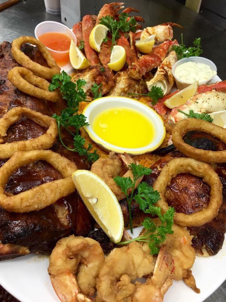 Our BBQ Feast · Shrimp, king crab legs, snow legs, 1/2 a chicken, whole rack of ribs all served over a bed of Spanis.