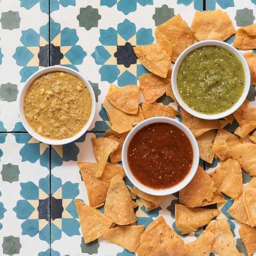 Chips and Salsa Trio · Nada's signature chips with Fire-roasted tomato ancho salsa, tomatillo verde, cruda salsa, and habanero “kreeper” salsa.