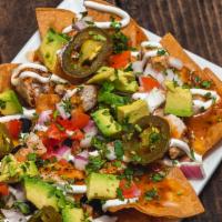 Grilled Chicken Nachos · Black beans, avocado, tomatoes, cilantro, red onions, cheese blend, jalapenos, chipotle sauc...