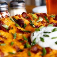 Pizza Skins · Roasted garlic mashed potatoes, cheddar cheese, Applewood smoked bacon and scallions baked o...