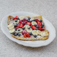 Cottage Cheese Crepes · Three crepes filled with cottage cheese topped with strawberries and blueberries.