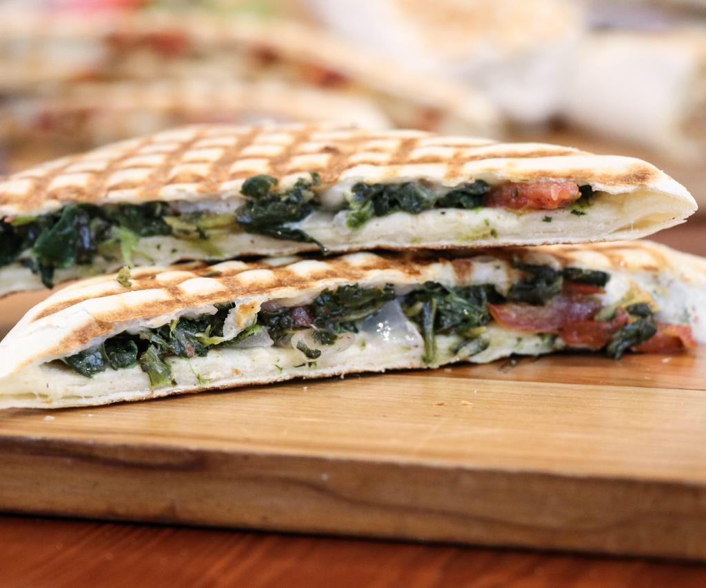 Spinach Zaki · Spinach, feta and mozzarella cheese, tomato, garlic sauce, extra virgin olive oil and lemon juice. Vegetarian. Zaki is grilled and pressed to perfection. Zaki is a registered trademark by Jasmin & Olivz.