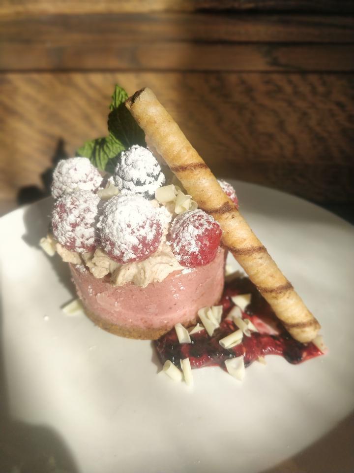 Raspberry Cheesecake · raspberry cheesecake topped with maple-cinnamon whipped cream and white chocolate whirls.