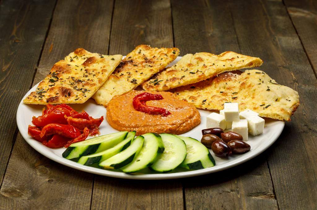 Hummus or Red Pepper Spread · Served with roasted tomato wedges, feta, kalamata olives, cucumbers and rosemary flatbread