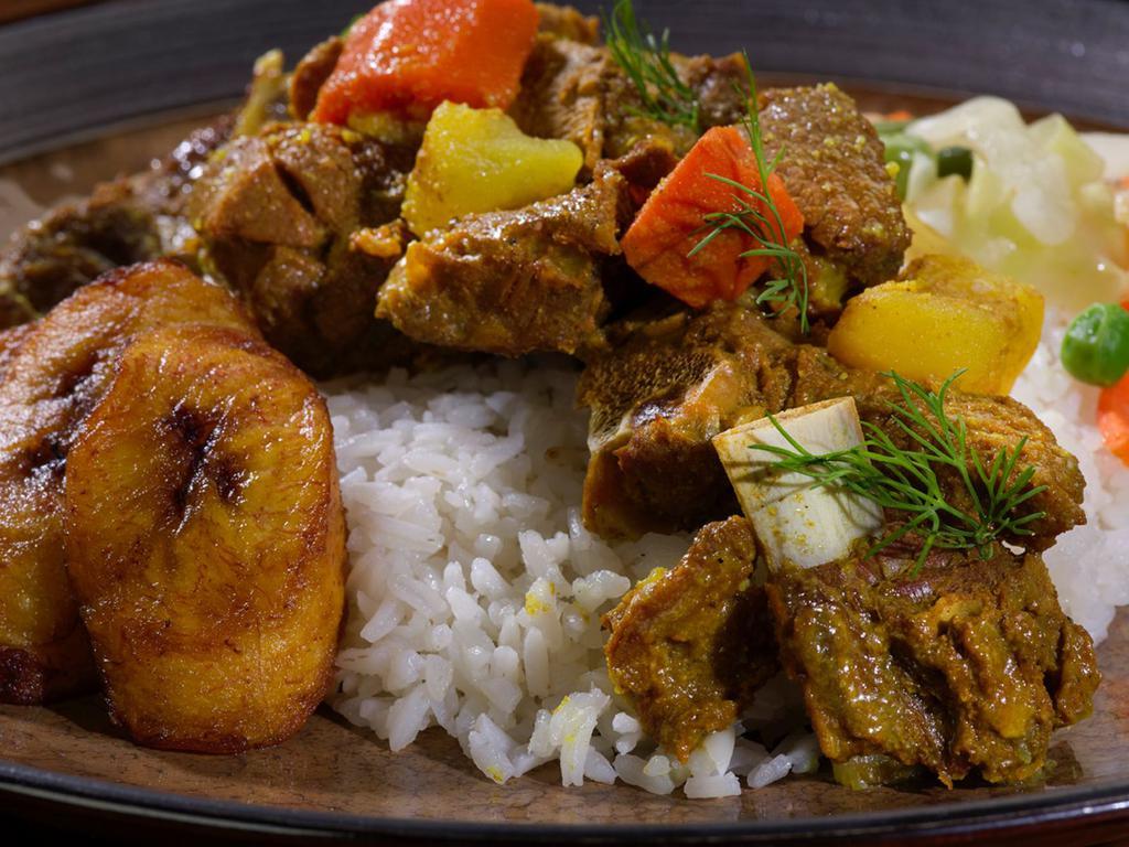 Curried Goat · Tender chunks of curry-clad goat cooked to the bone. Includes potatoes and carrots for a hearty anytime meal.
