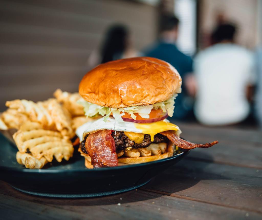 Hangover Burger · Sunny side up egg, american, bacon, waffle fries, dressed and brioche bun.