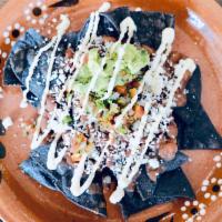 Serrano’s Nachos · Freshly made corn tortilla chips topped with black beans, crema, cotija cheese, pico de gall...