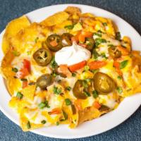 Nachos Azteca · Crisp, corn tortilla chips topped with beans, jalapenos, and melted cheddar cheese, garnishe...
