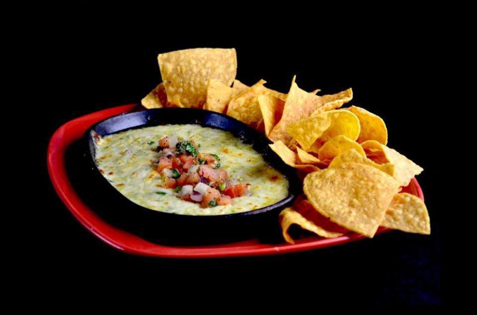 Azteca Queso Dip · Dip into a warm blend of selected cheeses, spinach and chiles, all baked together and served with fresh tortilla chips.