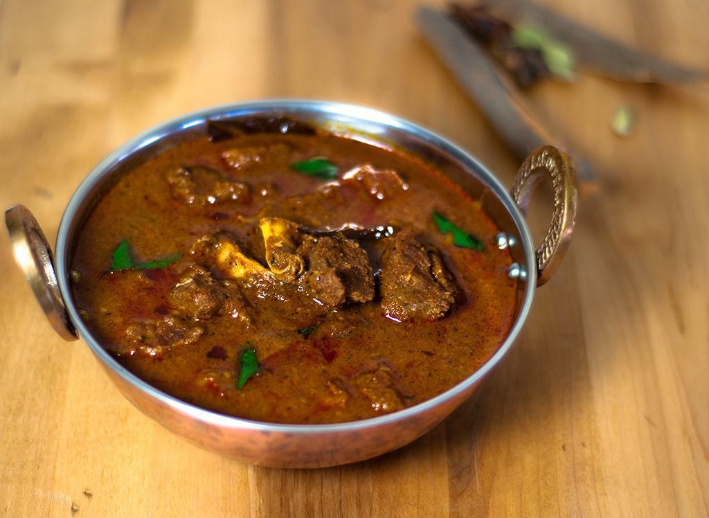 Goat Curry · Goat meat cooked with onion , ginger-garlic, tomato and spices