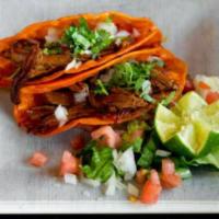Tacos de Barbacoa · 2 pieces. Guadalajara style red tacos, served with shredded beef and grilled onions.