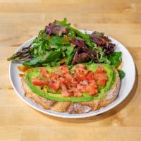 Avocado Toast · Open-faced sandwich with toasted sourdough bread, a spread of avocado, freshly cut tomatoes,...