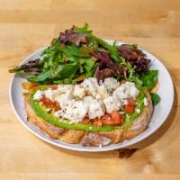 Avocado Toast with Feta · Open-faced sandwich with toasted sourdough bread, a spread of avocado, freshly cut tomatoes,...