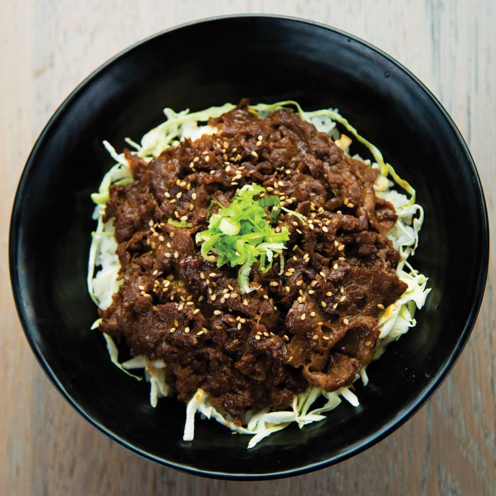 Umakara Beef Bowl · Thin-sliced Yakishabu beef marinated in our sweet & spicy Umakara sauce with sliced onions on a bed of white rice and shredded cabbage. Topped with chopped green onions and sesame seeds.