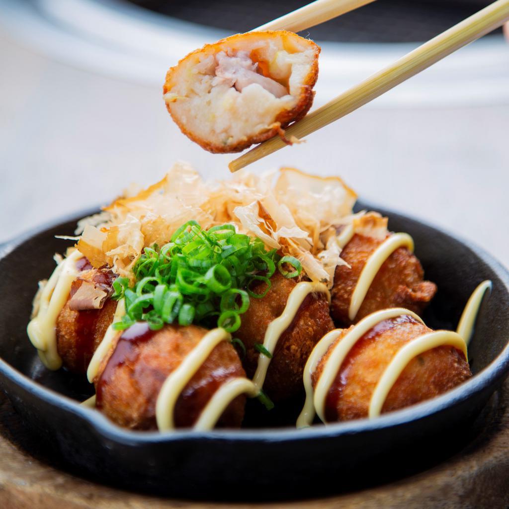 Takoyaki · Fried Octopus Balls! A street food classic straight from Osaka. Six fried octopus fritters drizzled with Takoyaki sauce and Japanese mayo. Topped with crushed bonito flakes and green onions.