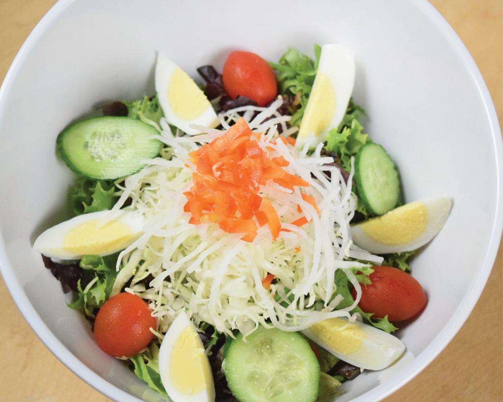 Gyu-Kaku Salad · Mixed greens, sliced cucumber, cherry tomatoes, and diced red bell pepper. Topped with a boiled egg (sliced), shredded daikon radish, and shredded cabbage. Served with Gyu-Kaku Dressing on the side.