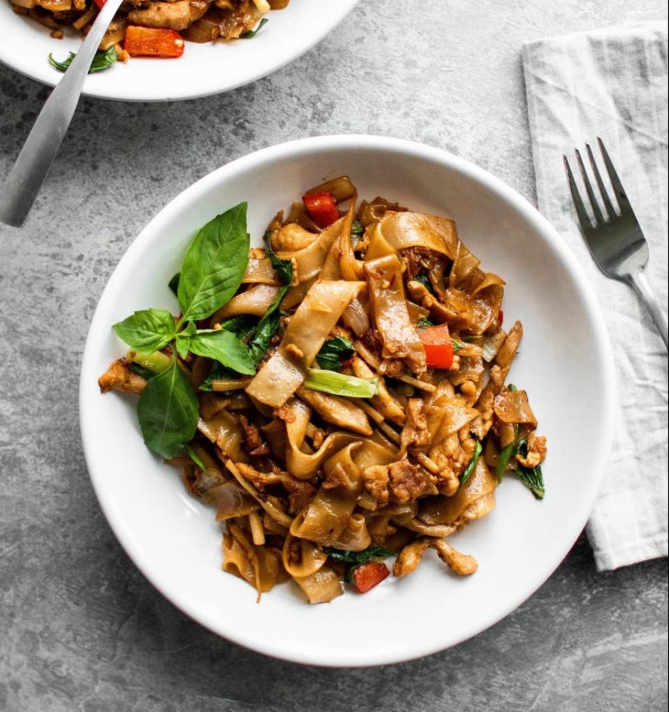 Drunken Noodles  · Stir-fried flat rice noodles in spicy chili paste. Served with egg, onions, bell peppers, tomatoes, mushrooms, broccoli, carrots and Thai basil. Spicy. 