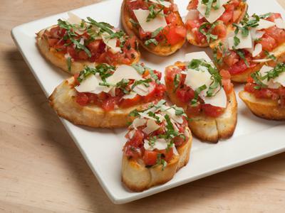 Lou's Bruschetta · Roma tomatoes, fresh basil, olive oil and shaved Parmesan on garlic rounds.