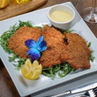 Veal Milanse · Breaded veal cutlet, pan-fried and served over arugula with lemon wedges.