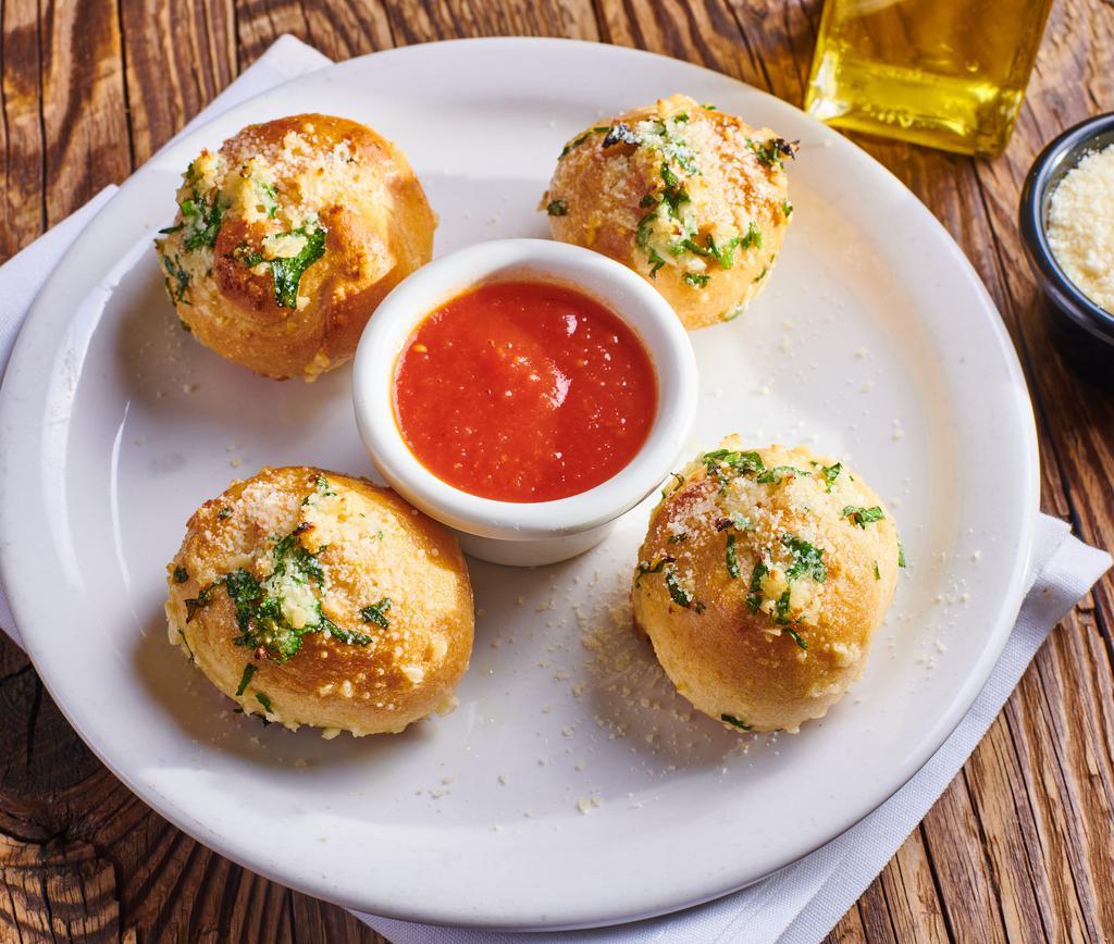 Garlic Knots · Pizza dough tied in a knot, baked and topped with parsley and garlic oil.  Served with a side of Marinara.