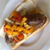 Boston Bay Jerk Pork Sausage · Grilled pork sausage seasoned with FiMi Kingston spices on a bun with sauteed onions, peppers.