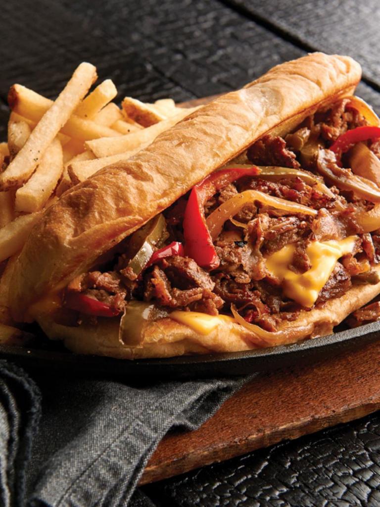 Philly Cheesesteak · Sliced sirloin, choice of American or provolone cheese, grilled onions, and peppers, served on a traditional toasted hoagie roll.