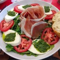 Caprese Salad · Fresh mozzarella, tomatoes, Paraggi pesto, balsamic glaze and fresh basil on a bed of arugula.
