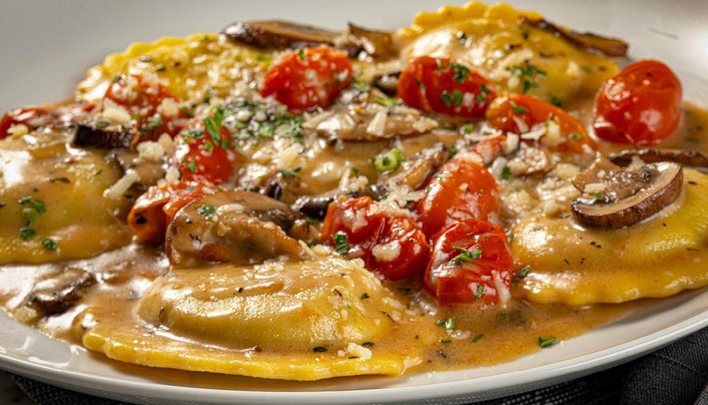 Ravioli Di Bello · Portobello ravioli, crimini mushrooms, roasted grape tomatoes, Grana Padano Zanetti, fresh thyme, brown butter sauce
