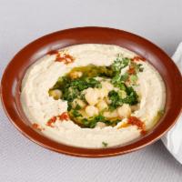 Hummus · Mashed chickpeas mixed with sesame seed sauce (tahini), lemon juice, garlic and topped with ...