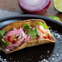 Pollo Guisado Taco · Chicken thigh, avocado lime salsa, pico de gallo, cotija, cilantro.