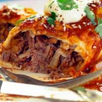 Barbacoa Enchilada. · Pasilla chili braised beef tenderloin, baked with jack cheese and topped with onions and cil...
