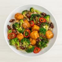 orange chickin' bowl · Crispy popcorn chickin’ tossed in orange glaze served over brown rice, garlic broccoli, cand...