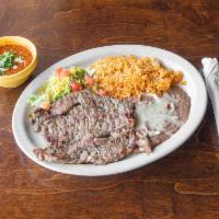 Carne Asada  · New York strip steak served with rice, beans and guacamole.